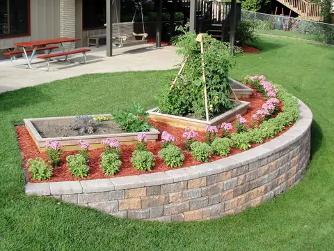 Curved segmental block retaining wall around a raised planting bed
