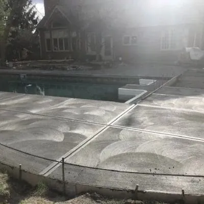 Newly poured broom-finish pool deck with curved control joints