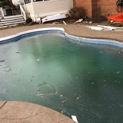 Pool with the old concrete deck broken out around the coping