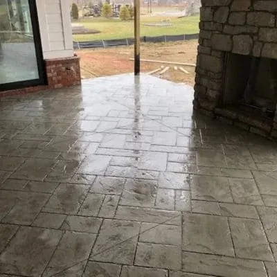 Wide view of a stamped gray concrete porch floor under a roof