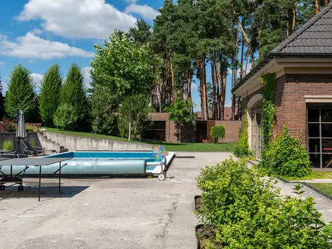 Backyard pool with a wide deck beside a house